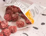 Fryst barf hundmat i form av köttbullar som vält ut ur en påse.