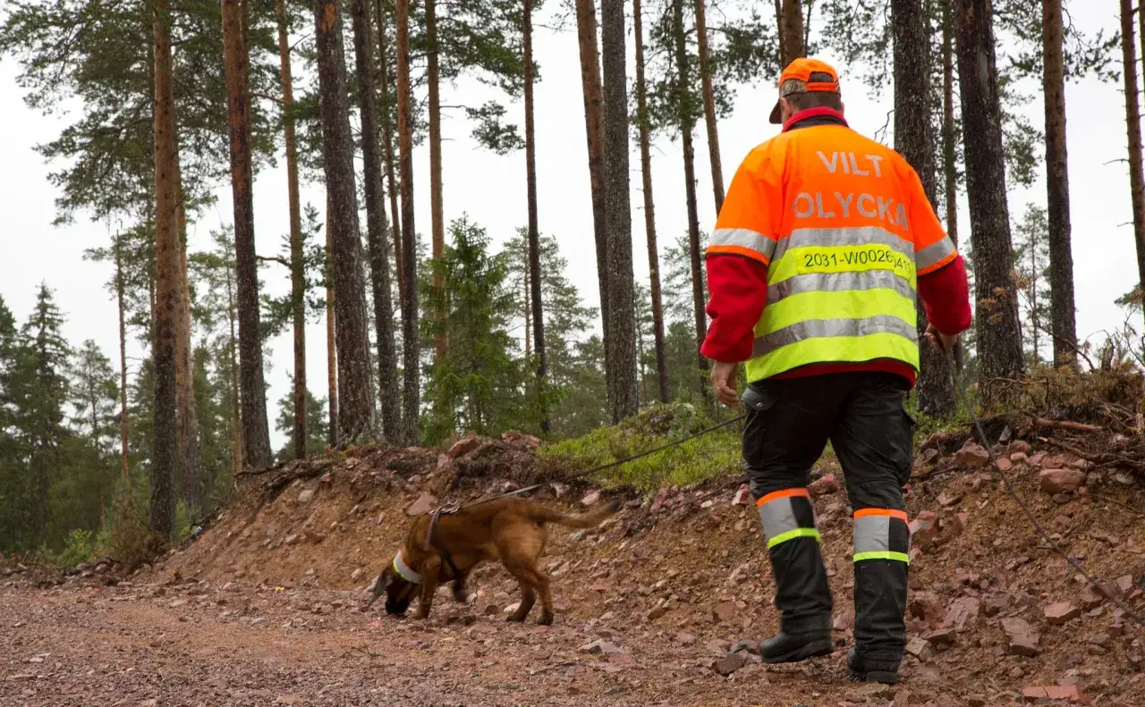 En hund och en person i varselkläder, med texten